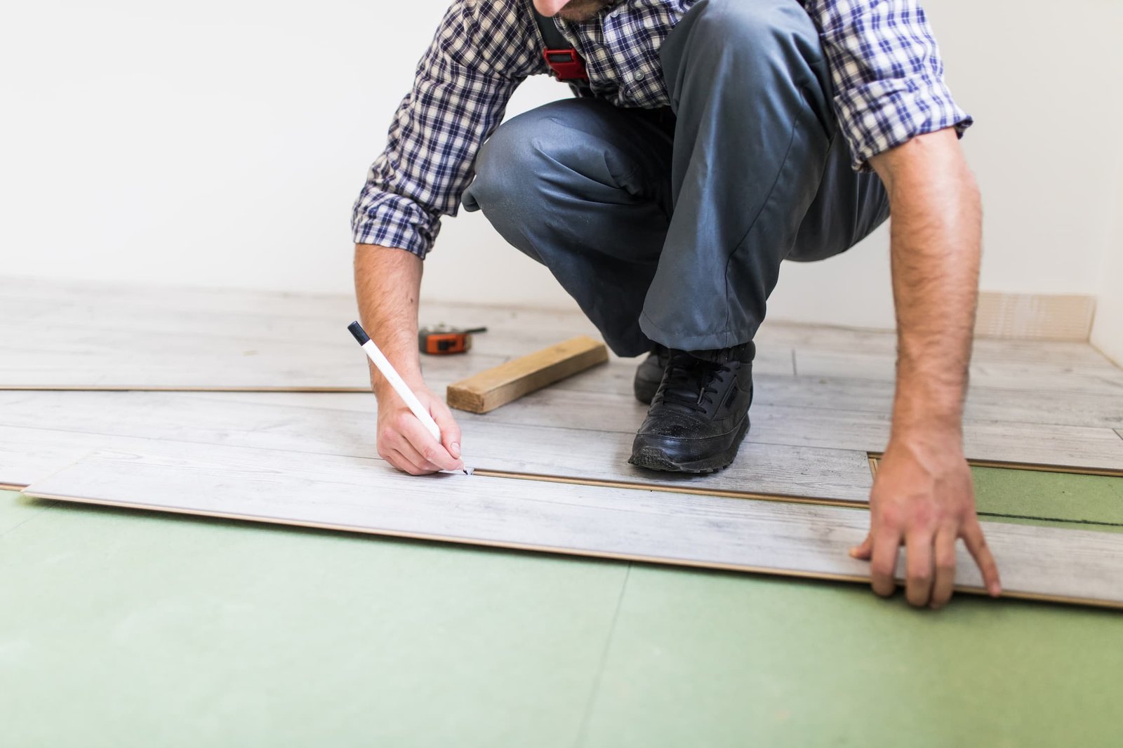 young worker lining floor with laminated flooring boards (1)